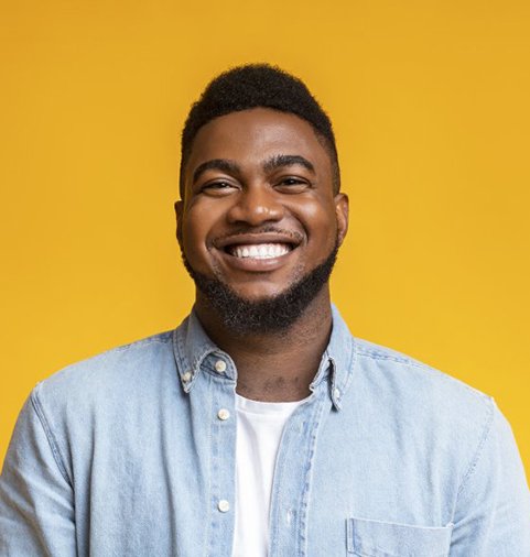 man smiling in front of a yellow background 