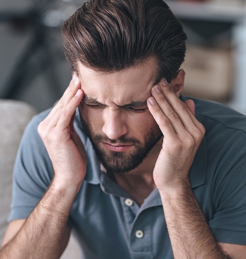 Man with headache holding forehead