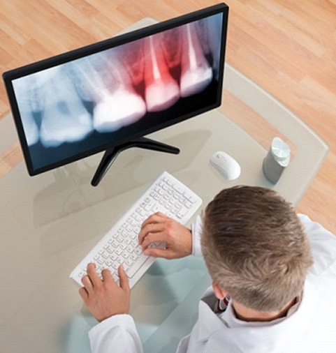 A dentist examining a dental X-ray.