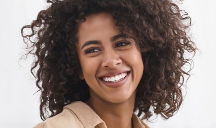 woman with curly hair and perfect smile smiling
