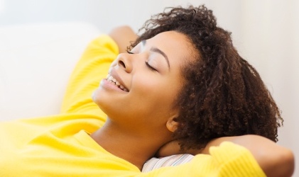 woman in yellow relaxing on bed