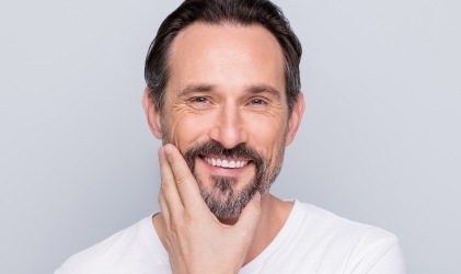 man with beard in white shirt smiling