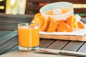 Glass of orange juice and sliced oranges